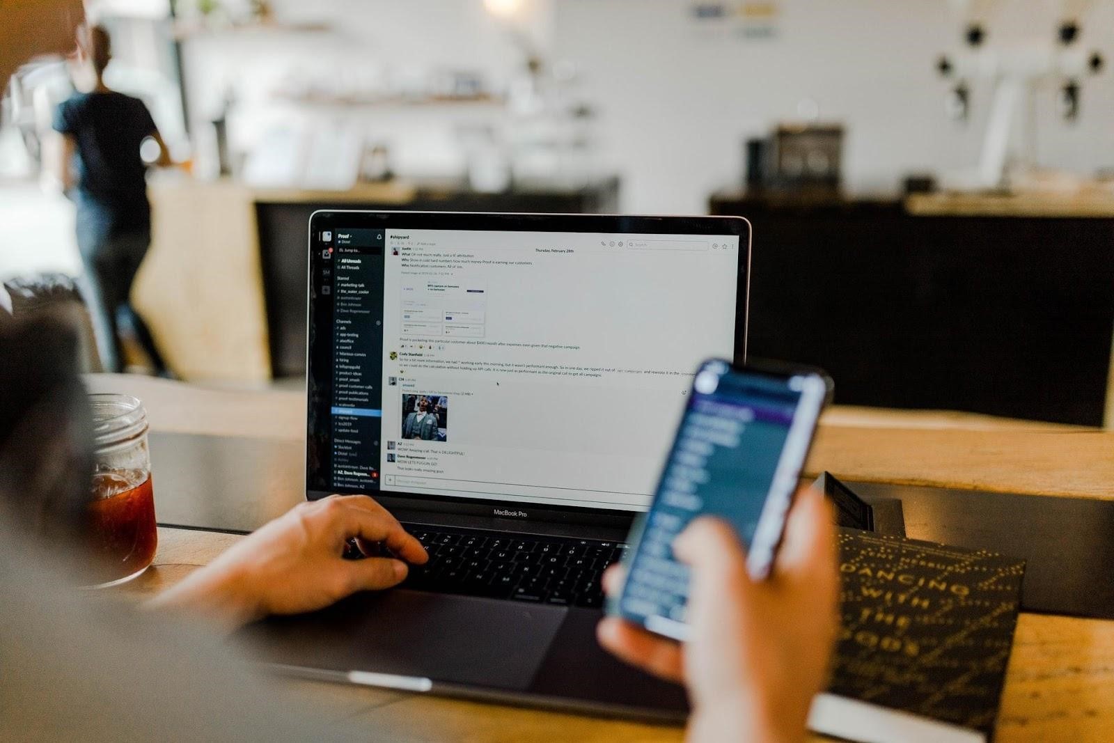 user working on laptop and phone